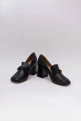 Zapato clásico de cuero azul marino, con aplique decorativo en el empeine y taco cuadrado.