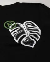 Remera negra de manga corta con cuello redondo y mangas largas de punto color gris claro.