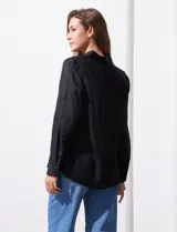 Camisa blanca de lyocell, marca Cyrus. Tiene cuello con solapa, abertura central con botones, mangas largas regulables con presilla y botón, y dos bolsillos delanteros aplicados.