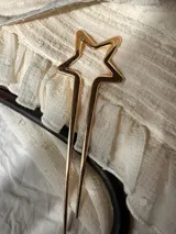 Pinza dorada tipo peineta con forma de estrella.