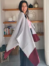 Ruana tejida en punto liso, bicolor, con cuerpo principal gris claro y un borde ancho en color bordó oscuro.