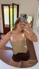 Top corto de ecocuero color beige con tirantes finos dorados y espalda descubierta.