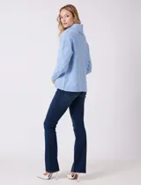 Buzo de punto grueso color beige, con cuello volcado y textura en relieve. Tiene mangas largas de corte hombro caído y puños anchos.