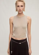 Top color beige de tejido de punto fino, cuello redondo y sin mangas.