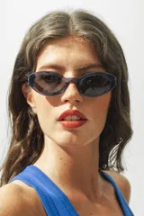 Lentes de sol con marco de acetato color lila y lentes oscuros ovalados.