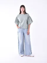 Blusa negra de mangas cortas con volados y escote redondo.