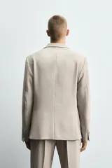 Blazer slim fit color beige confeccionada en tejido con viscosa. Cuello con solapas de muesca, manga larga acabada en puño con detalle de botones, bolsillo de vivo en pecho y de solapa en cadera, detalle bolsillo interior, bajo con aberturas en espalda y cierre frontal con botones.