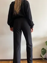 Pantalón negro de corte recto con textura suave y cintura elástica.