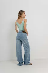 Pantalón de jean azul de tiro alto y corte wide leg, con detalle de parche animal print en la parte trasera.