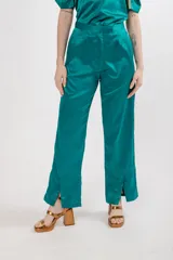 Pantalón de seda color celeste, de tiro alto y corte recto, con pinzas en la pretina y tajos en el ruedo.