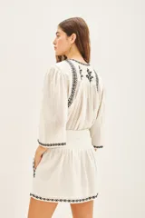 Minifalda blanca de algodón con bordados geométricos negros en el ruedo y cintura.