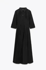 Vestido midi negro tipo gabardina, con cuello solapa, manga tres cuartos con puño y trabillas en el hombro, bolsillos laterales ocultos, pinzas y cierre frontal con botones.