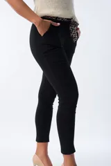 Pantalón negro de corte aline con cintura plisada y lazo estampado animal print.