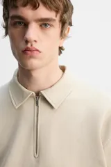 Sudadera negra de algodón con cuello polo y cierre de cremallera.