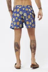 Short de baño con estampado de hojas de palmera en tonos beige, verde y naranja.