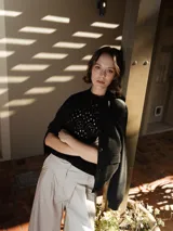 Cárdigan negro de punto con cierre de botones y bolsillos frontales. Confeccionado en mezcla de poliéster reciclado, poliéster y nailon.