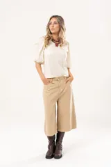 Bermuda de jean color beige, tiro medio, con bolsillos delanteros y traseros.