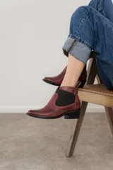 Botín Chelsea de cuero marrón con elástico lateral y tacón bajo.
