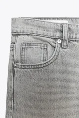 Pantalón de jean azul oscuro, de corte wide leg y tiro medio, con cinco bolsillos y cierre frontal con cremallera y botón metálico.