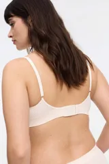 Top color piel, de microfibra seamless con dibujo de trenza, sin aro ni copa, con breteles regulables y cierre de tres posiciones en la espalda.