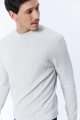 Buzo de punto color gris claro melange con textura acanalada.