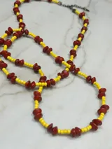 Collar largo de cuentas rojas y amarillas.