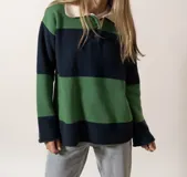 Sweater verde y azul marino con cuello polo blanco y cierre parcial con botones.