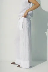 Pantalón blanco de lino, de corte palazzo y cintura con cordón ajustable.