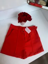 Short sastrero rojo con hebilla y bolsillos laterales.
