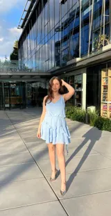 Vestido corto celeste con breteles finos, escote en V y falda con volados.