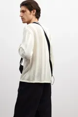 Buzo color crema en punto pointelle de mezcla de algodón, lino y viscosa. Modelo de hombros caídos con cuello redondo y bajo recto. Borde enrollado en cuello, puños y bajo.