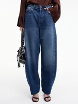 Pantalón denim azul de corte amplio, tiro alto, con bolsillos delanteros y traseros, y terminación desflecada en el bajo.