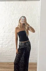 Pollera larga de encaje negro con abertura frontal y cintura elastizada.