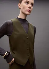 Chaleco negro con cuello en pico, diseño crop y cierre frontal con botones.