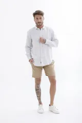 Camisa de rayas en tonos claros, con cierre frontal de botones y corte clásico.