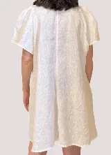 Vestido camisero blanco de lino con cuello clásico, cartera a la vista, mangas cortas acampanadas y bordados de motivos marinos.