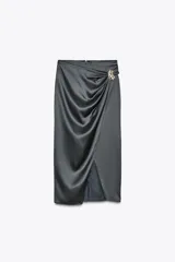 Falda midi gris de satén con drapeado frontal, abertura lateral y aplique dorado.
