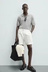 Bermuda de algodón color marrón oscuro, de corte regular fit, con cintura elástica ajustable mediante cordón. Presenta bolsillos laterales y un bolsillo trasero de vivo.