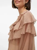 Blusa color beige con volados, cuello redondo y mangas largas abullonadas con puños abotonados.