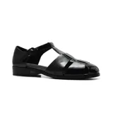 Sandalias de cuero negro con diseño de tiras cruzadas y hebilla lateral. Taco bajo.