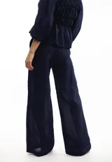 Pantalón marrón de lino, de corte amplio y cintura elástica con cordón ajustable.