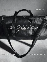 Bolso duffel negro de cuero sintético con logo de ancla bordado en rosa. Tiene doble asa de mano reforzada, correa de hombro regulable y desmontable, cierre superior con doble cremallera y tres bolsillos (dos exteriores y uno interior).