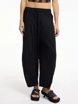 Pantalón negro tipo chino con pinzas delanteras, bolsillos laterales y pretina con elástico.