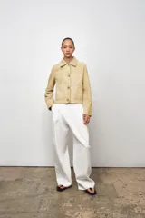 Chaqueta de mujer realizada en piel de ante color beige. Tiene cuello solapa, manga larga, bolsillos de plastrón en delantero y cierre frontal con botones.