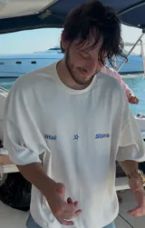 Camiseta celeste con estampado frontal de la frase "Ittai Stars" y una estrella. En la parte posterior tiene un estampado de un llavero con llaves y dijes.