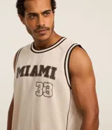 Musculosa deportiva de baloncesto color crema con cuello redondo y ribete en marrón. Estampado frontal con la palabra "Miami" y el número 33 en marrón.