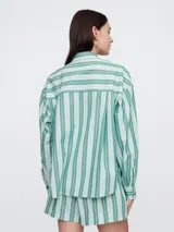 Camisa de popelina a rayas verticales rosas y blancas, de corte holgado y manga larga.
