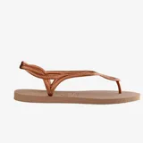 Ojotas Havaianas modelo Luna, color cobre metalizado, con tiras finas que se cruzan alrededor del tobillo y un detalle ovalado en la parte frontal que se repite en la suela.