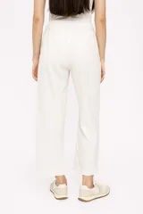 Pantalón ancho de tiro alto color crema, confeccionado en lino, con cintura elástica y cordón ajustable.