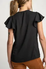 Blusa blanca con escote en V, mangas cortas con volados y cierre frontal con botones.